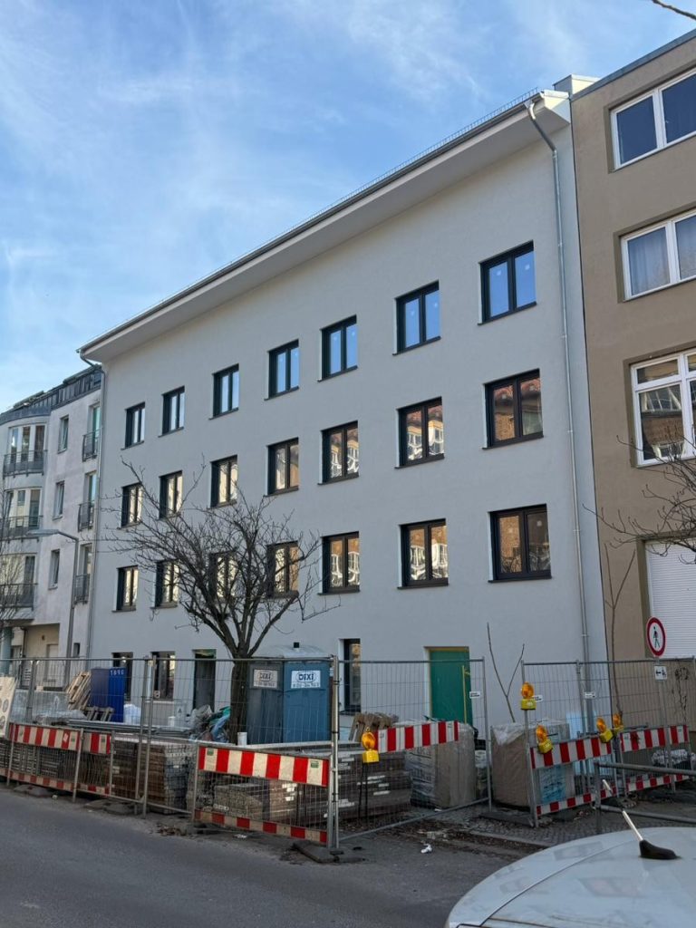 Hausotterstraße – Straßenansicht im Hochformat Straßenansicht des Wohngebäudes in der Hausotterstraße in Berlin mit heller Fassade und dunklen Fensterrahmen